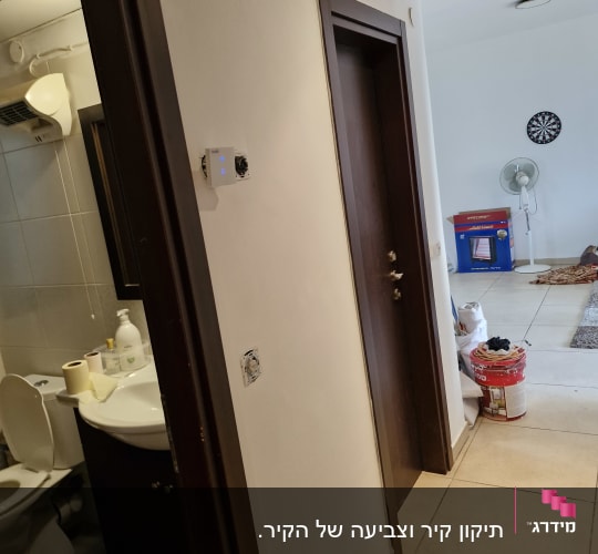 מסדרון עם דלתות, חדר אמבטיה, מאוורר ודלי צבע
